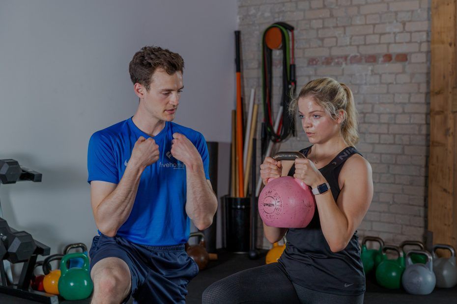 Ein Mann und eine Frau trainieren gemeinsam in einem Fitnessstudio.
