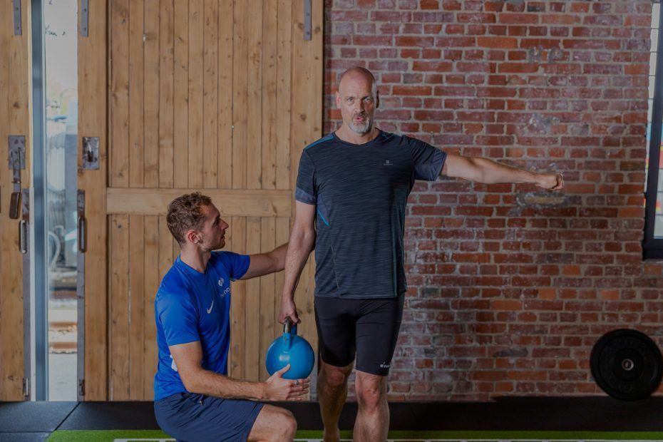 Zwei Personen trainieren gemeinsam in einem Fitnessstudio, beide konzentriert auf ihre Übungen.