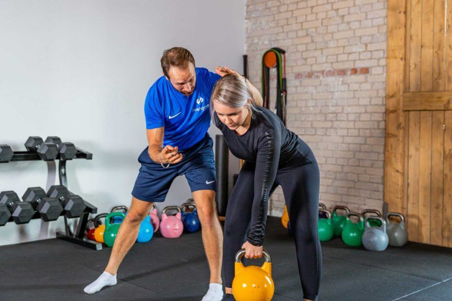 Zwei Personen führen ein Workout in einem Fitnessstudio durch.