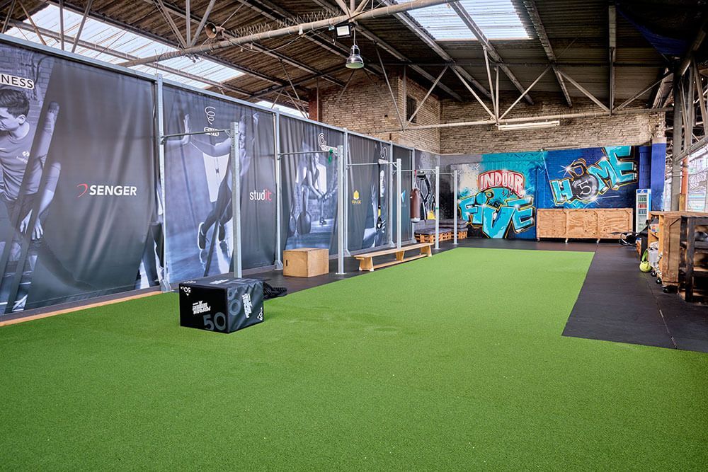 Outdoor-Räumlichkeiten mit Sitzgelegenheiten und Trainingsstationen von FiveHomeFitness