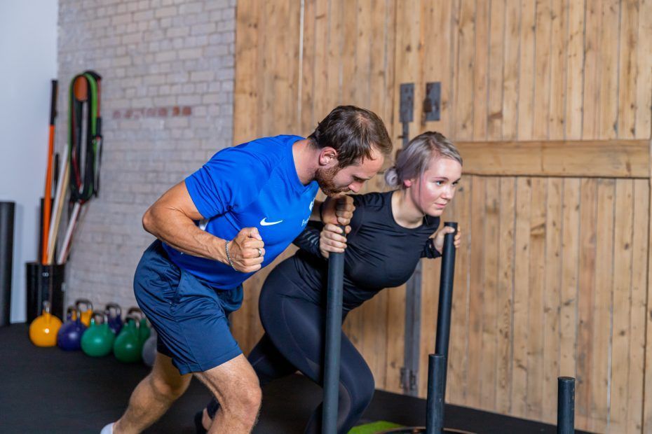 Zwei Personen trainieren im Fitnessstudio.